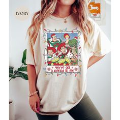 a woman wearing a t - shirt with an image of cartoon characters on it