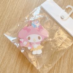 a hello kitty keychain sitting on top of a table next to a bag