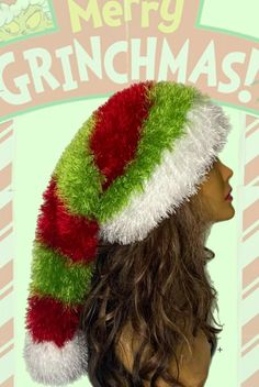 a mannequin head wearing a green and red santa hat with the words merry grinmas on it