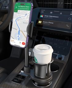 a cell phone is connected to a cup holder in the dashboard of a car with a map on it