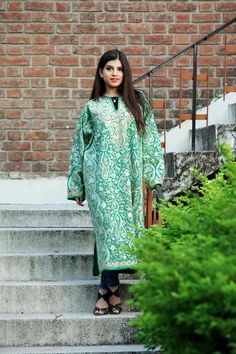 A stunningly marvellous Pheran. This Pheran features intricate Kashmir Aari embroidery on all-over the front side and on the sleeves.- - - - - - - - - - - - - - - - - - - - Product Details- Condition: Brand New (made to order)- Style: Phiran Tunic- Fabric: Pure Wool- Colour: Green- Embroidery: Jaal Aari Work- Embroidery Colour: Multi-Colour- Standard Length: 40" | Can be customized- Care Instructions: Dry Clean Only**If you want the Tunic to be shorter or longer, just send us a message, and we w Embroidered Long Sleeve Jamawar Salwar Kameez, Embroidered Jamawar Fabric For Eid, Green Jamawar Long Sleeve Traditional Wear, Green Resham Embroidered Jamawar Kurta, Green Jamawar Kurta With Resham Embroidery, Intricate Embroidery Jamawar Fabric, Traditional Unstitched Embroidered Kaftan, Unstitched Embroidered Traditional Kaftan, Ceremonial Embroidered Jamawar Kurta