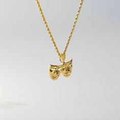 Comedy and tragedy mask pendant so bold, in gold they're cast and never grow old.  This 14K gold Two Face Mask Pendant features the iconic twin masks of theater - one laughing, and the other crying. The laughing mask is depicted with a wide grin and pronounced eyebrows, while the crying mask features a downturned mouth and exaggerated tears. Show off your passion for the performing arts with this eye-catching 14k gold necklace with pendant. If you're looking for an elegant gold pendant for theat Downturned Mouth, Two Face Mask, Laughing Mask, Drama Masks, Tragedy Mask, Comedy And Tragedy, Two Face, Never Grow Old, Malachite Pendant