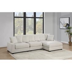 a white sectional couch sitting in front of a window