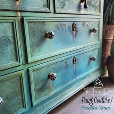 an old dresser has been painted green with gold knobs and pulls on the drawers