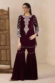 Maroon velvet short kurta with Kashmiri multicolored thread and gold zari embroidery highlighted with metal sequins, ghunghroo and tassels. Comes with sequin highlighted gharara. - Aza Fashions Velvet Sharara For Party And Festivals, Velvet Semi-stitched Sharara For Party, Party Velvet Sharara With Mirror Work, Party Velvet Sharara Semi-stitched, Party Velvet Semi-stitched Sharara, Velvet Sharara For Navratri Festival, Party Velvet Sharara With Dupatta, Semi-stitched Velvet Sharara With Traditional Drape, Velvet Sharara With Dabka For Party