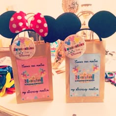 there are two bags with minnie mouse ears on top of each bag, one has a name tag and the other has an image of mickey mouse's head