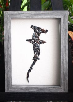 a framed photo of a lizard in the shape of a man's body is shown