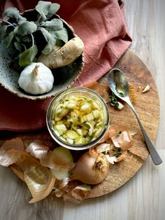 a bowl filled with food sitting on top of a wooden cutting board next to a spoon