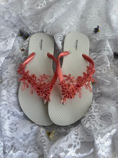 These beautiful white flip flops are hand wrapped in coral satin ribbon, and adorned with a matching lace appliqué with sequins in a coral color. Ribbon color is coral if you are needing other colors of ribbon or decoration please contact me and will be happy to accommodate you! All flip flops are handmade to order and the production time is 5-7 business days and then please allow additional time for shipping. Amazing for beach, weddings, flower girl or a fancy event, you choose! Please choose y Summer Beach Lace Sandals, Elegant Orange Beach Sandals, White Sandals For Summer Ceremonies, White Summer Ceremony Sandals, White Summer Flip Flops As Gift, White Flip Flops As Summer Gift, Elegant Pink Summer Flip Flops, White Flip Flops For Beach Season Parties, White Sandals For Spring Gift