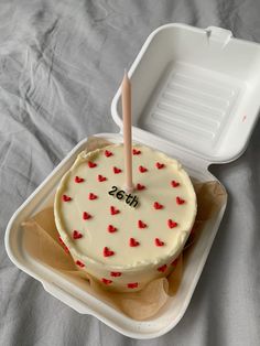 a cake in a plastic container with a stick sticking out of it