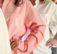 three women wearing pink shirts with monogrammed letters on the front and one in white