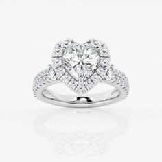 a heart shaped diamond ring with diamonds on the band and an intricate halo style setting