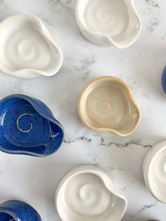 several blue and white bowls sitting on top of a marble countertop next to each other