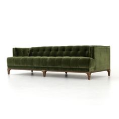 a green velvet couch with wooden legs on an isolated white background for use in interior design