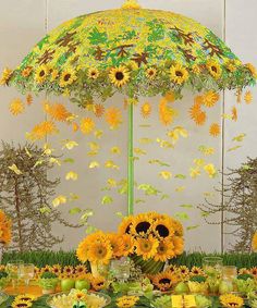 an umbrella decorated with sunflowers and daisies is displayed in front of a backdrop