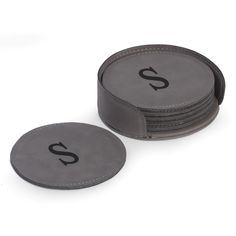 two round coasters sitting next to each other on a white surface with black letters