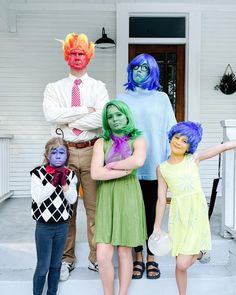 a group of people in costumes standing on the front porch