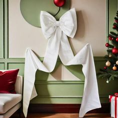 a white bow tie hanging on the wall next to a christmas tree