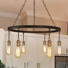 a chandelier with five light bulbs hanging from it's center ring in a kitchen