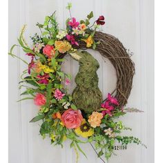 a wreath with flowers and a rabbit on it