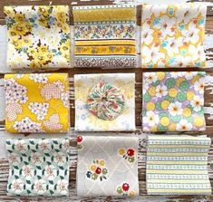 many different types of cloths on a wooden table with white and yellow flowers in them