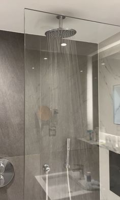 the shower head is connected to the faucet in this modern bathroom with marbled walls and flooring