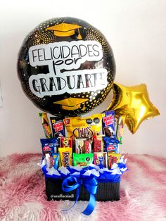 a balloon with congratulations written on it and some candies in the box next to it