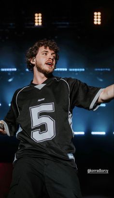 a male in a black and white jersey is holding his arms out to the side