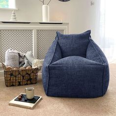 a blue bean bag chair sitting on top of a floor next to a coffee cup