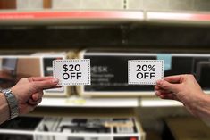 Someone holding a coupon in each hand - one for $20 off and one for 20% off.