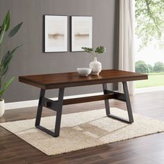 a wooden table sitting on top of a hard wood floor next to a potted plant