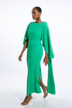 a woman wearing a green dress and heels