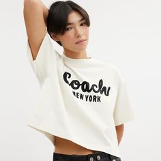 Detailed with our cursive Coach script this cropped T-shirt is crafted of soft cotton. The boxy silhouette features a comfortable easy to wear dropped shoulder. | Coach Cursive Signature Cropped T-Shirt - Women's Size Small - Cream Cropped Cotton T-shirt With Logo Print, Cotton Cropped T-shirt With Logo Print, Boxy Cotton Cropped Shirt Trendy Style, Logo Print Cropped T-shirt For Spring, Cropped Logo Print T-shirt For Spring, Spring Cropped T-shirt With Logo Print, Oversized Short Sleeve Cropped T-shirt In Trendy Style, Oversized Cropped T-shirt With Short Sleeves In Trendy Style, Graphic Cropped T-shirt With Logo Print