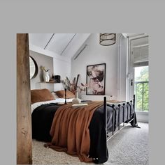 a bed room with a neatly made bed and pictures on the wall next to it