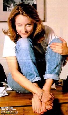 a woman sitting on top of a wooden table