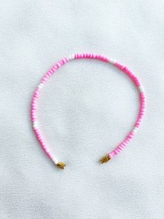 Handcrafted pink and white beaded anklet/bracelet. Made using small colourful round glass beads and finished with a gold-plated barrel clasp closure. Pair it with our matching Necklace.  * Weight: 3g   * Width: 5mm/2mm  * Made in UK  * Code: 111APWS The very best in unique, handmade pieces from BAM-BAM, our anklets and bracelets make great accessories for the beach, festival or club. These small beads have a dainty appearance and can take your best looks from day to night. Pink Tiny Beads Anklets For Summer, Pink Anklets With Tiny Beads For Summer, Adjustable Pink Heishi Beads, Adjustable Pink Anklet With Colorful Beads, Summer Pink Beaded Bracelets With Heart Beads, Pink Heishi Beads For Beach, White Beaded Anklets With Round Beads, Pink Heart Beads For Summer, Beaded Anklet