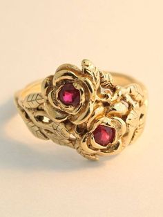 Two detailed roses make up this elegant ring, their stems entwining and forming the band. The ring is cast in solid 14K gold and two 3 mm rubies are set in the center of each rose.  Indulge yourself or someone special in this sparkling bouquet.We will contact you to let you know if we have your chosen ring size in stock or when to expect shipment.All Marty Magic Jewelry is packaged in a beautiful ring box embossed with the gold foil Marty Magic dragon logo. Perfect for any occasion!Designed in S