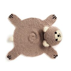 a brown teddy bear laying on top of a rug