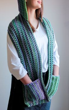 a woman wearing a green and purple crocheted scarf