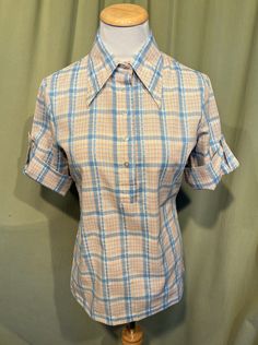 "This is an adorable vintage blouse from the 70s or so. Labeled Lucky Pierre. No size tag. The bust measures 34\" with measurements below. Made of a blue & white cotton blend in a plaid pattern. The pullover blouse closes down the front bodice with plastic buttons. The blouse has elbow length sleeves cuffed up with buttons and tabs. Hem is straight. It is hip length.   The blouse is in very good condition!  No damage. No stains or soil. Super cute!  If you have never worn vintage before, please How To Make A Blouse Smaller, Vintage Blouses, Plaid Pullover, Vintage Blouse, Elbow Length Sleeve, Blouse Vintage, Cotton Blouses, White Plaid, Hip Length