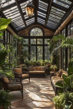 a sun room filled with lots of plants and furniture next to large glass windows on the ceiling