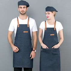 two people wearing aprons and hats standing next to each other in front of a gray wall