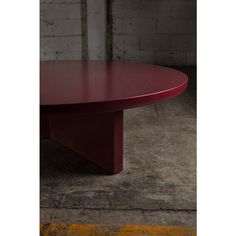 a red table sitting in front of a brick wall