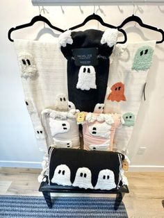 a chair that has some pillows on it with ghost decorations hanging from the wall behind it