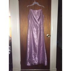 a purple dress hanging on a wooden door