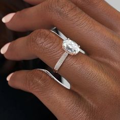 a woman's hand with a ring on her finger and an oval diamond in the middle