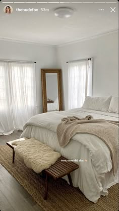 a bedroom with a bed, mirror and bench