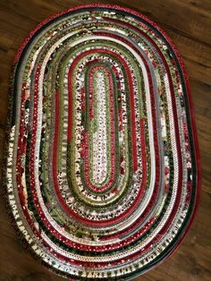 a red and green patchwork rug on top of a wooden floor