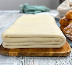 a wooden cutting board topped with doughnuts on top of a table