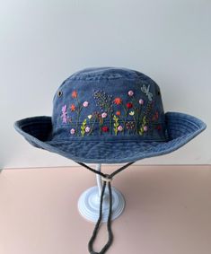 a blue hat with flowers on it sitting on top of a table